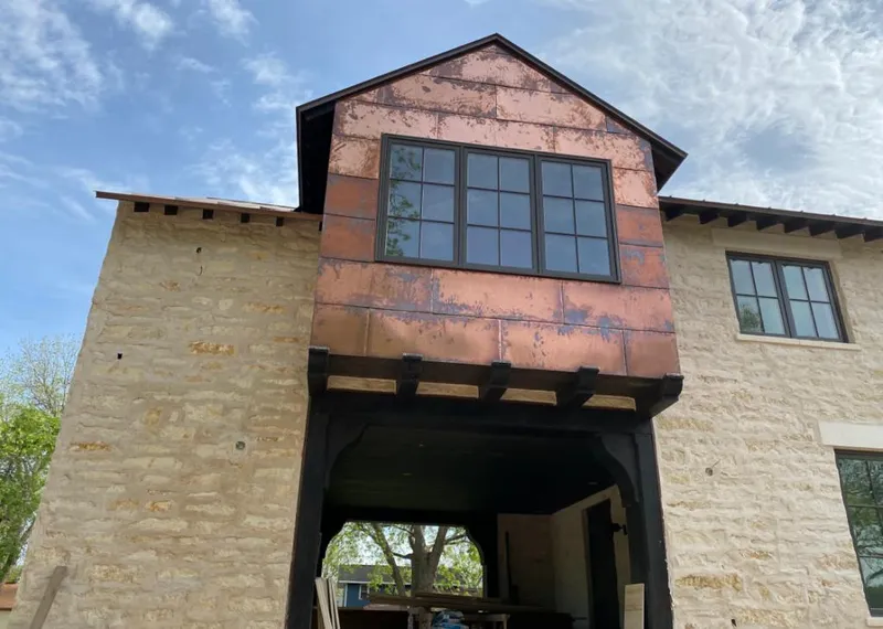 Copper metal panel facade on a stone building for Skylight Installation in Myrtle Grove